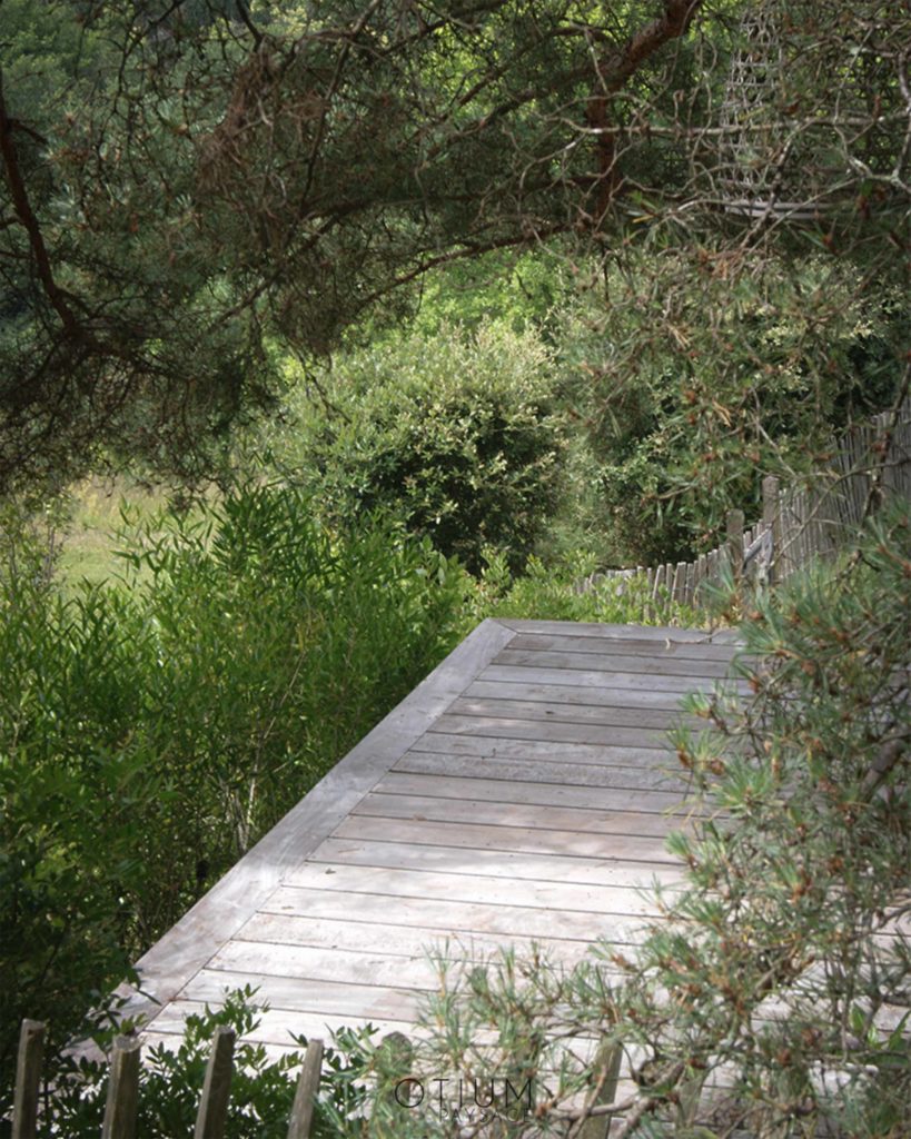 Terrasse en bois sur mesure intégrée dans un jardin paysager à Sarlat, par Otium Paysage.